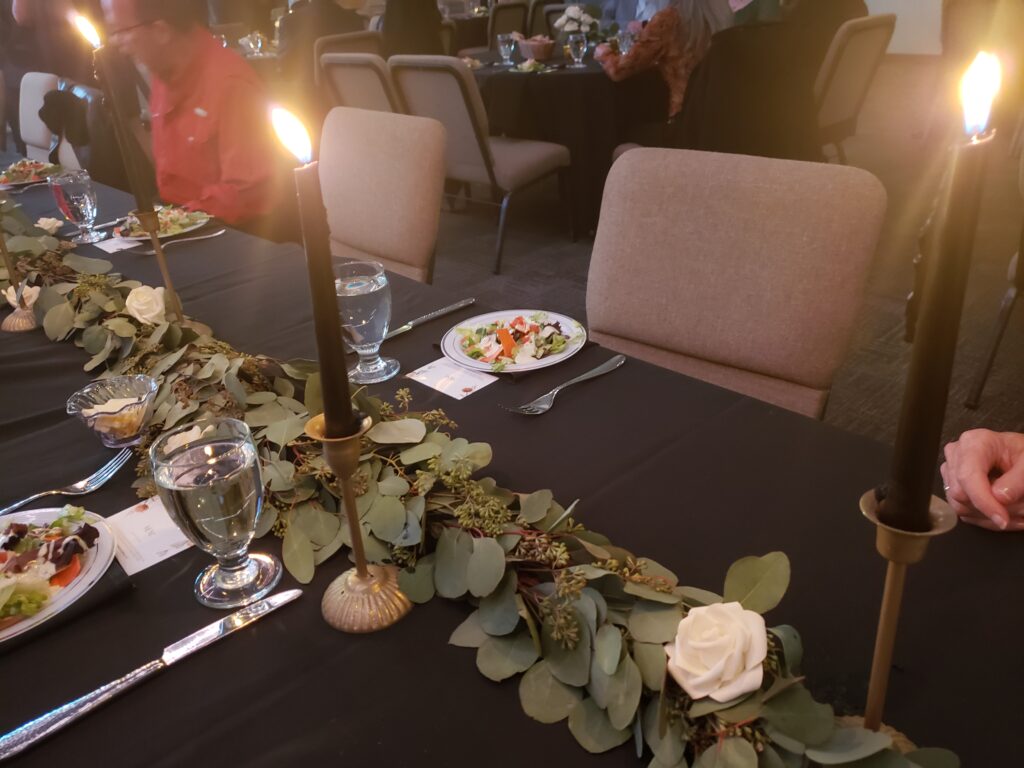 a table with a black tablecloth and candles